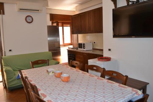 une cuisine avec une table et des chaises ainsi qu'une télévision dans l'établissement A Casa Di Luca, à Diamante