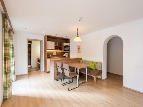 a kitchen and dining room with a wooden table and chairs at Lovely Apartment with Sauna, Ski Storage, Pool, Terrace in Wald im Pinzgau