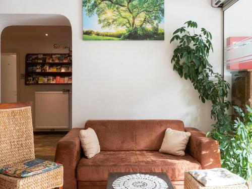 a living room with a brown couch and a painting on the wall at Lovely Apartment with Sauna, Ski Storage, Pool, Terrace in Wald im Pinzgau