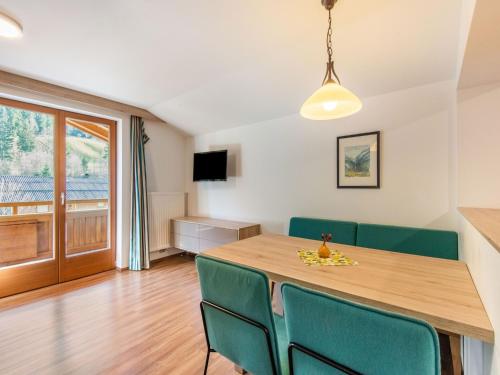 a dining room with a table and green chairs at Lovely Apartment with Sauna, Ski Storage, Pool, Terrace in Wald im Pinzgau