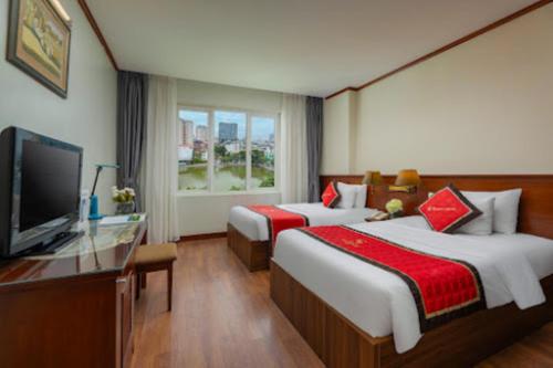 a hotel room with two beds and a flat screen tv at Sunny Hotel in Hanoi
