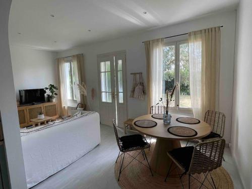 a living room with a table and a bath tub at La petite bleue, Villa 300 m de la mer in Agon Coutainville