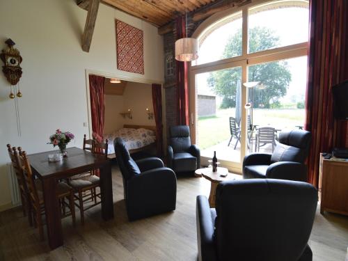 a living room with a table and chairs at Quaint Farmhouse in Geesteren with Meadow View in Geesteren