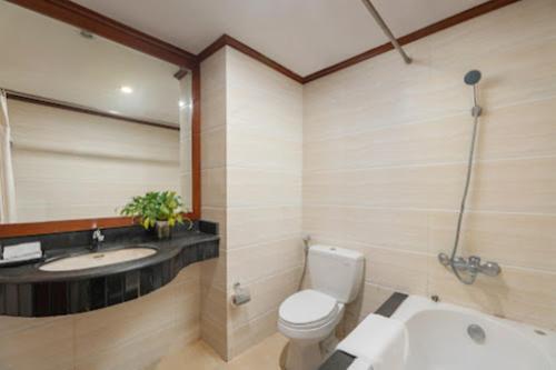 a bathroom with a toilet and a sink and a tub at Sunny Hotel in Hanoi