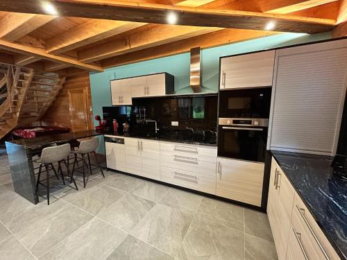 a kitchen with white cabinets and black counter tops at Chalet in Ventron near La Bresse Ski Area in Ventron