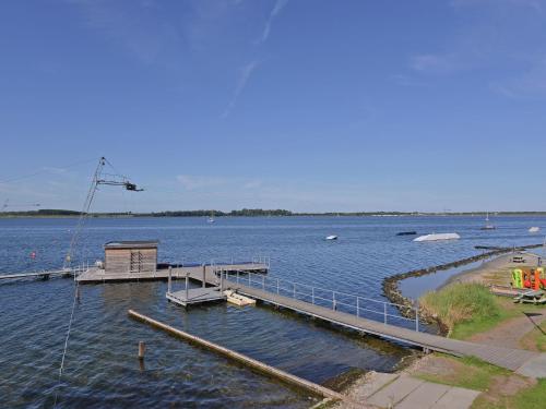 a dock in a large body of water with boats at Waterfront penthouse with roof terrace and private jetty in Kamperland