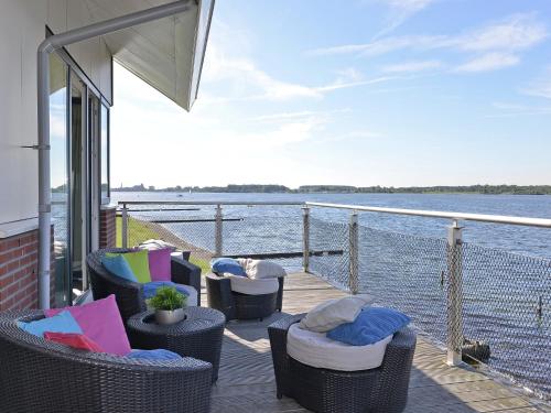 a deck with chairs and a view of the water at Waterfront penthouse with roof terrace and private jetty in Kamperland