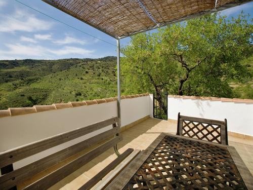 a bench on a balcony with a view of the mountains at Beautiful holiday home in Laroya with shared pool in Laroya