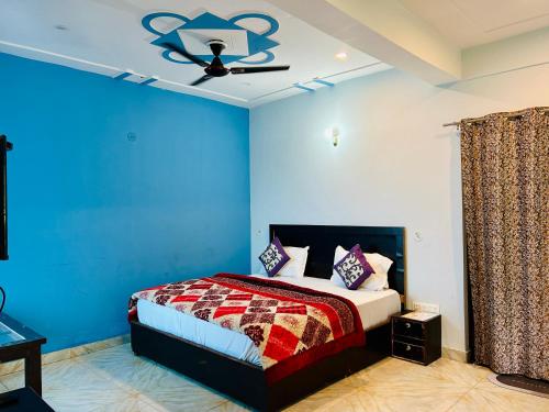 a bedroom with a bed with blue walls and a ceiling at Green Valley Hotel in Lansdowne