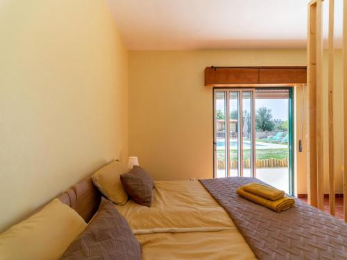 a bedroom with a bed and a large window at Rural holiday home in Netos-Almagreira with shared pool in Lagares