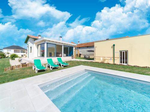 a swimming pool with two chairs and a house at Rural holiday home in Netos-Almagreira with shared pool in Lagares