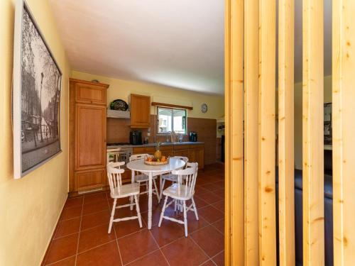 a kitchen with a table and chairs in a room at Rural holiday home in Netos-Almagreira with shared pool in Lagares