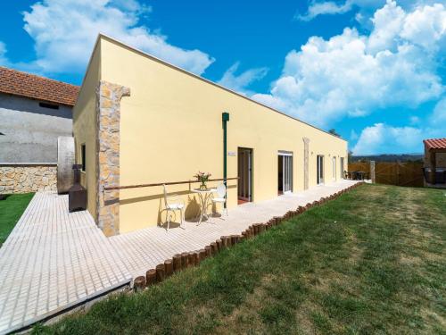 a large white building with a grass yard at Rural holiday home in Netos-Almagreira with shared pool in Lagares