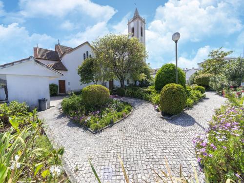 a courtyard with a church with a clock tower at Rural holiday home in Netos-Almagreira with shared pool in Lagares