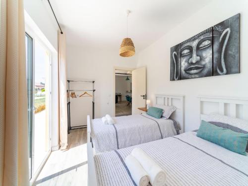 two beds in a room with a large window at Rural holiday home in Netos-Almagreira with shared pool in Lagares