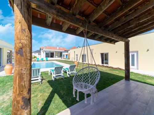 a patio with a swing and a pool at Rural holiday home in Netos-Almagreira with shared pool in Lagares