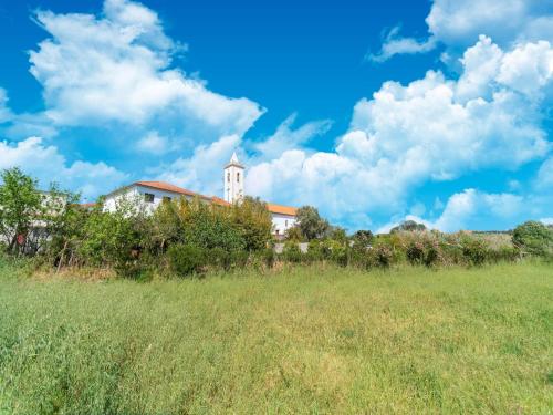 a field with a building in the background with a blue sky at Rural holiday home in Netos-Almagreira with shared pool in Lagares