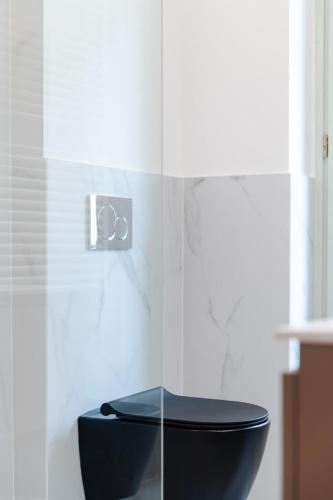 a bathroom with a black toilet in a room at The Silk House in Como
