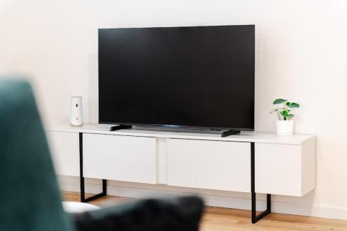 a flat screen tv sitting on a white entertainment center at The Silk House in Como