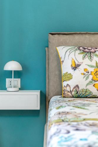 a bed with a pillow and a lamp on a wall at The Silk House in Como