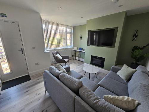 a living room with a couch and a flat screen tv at House - Sleeps 4 - Parking - Garden - City Centre in Leeds