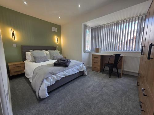 a bedroom with a bed and a desk and a window at House - Sleeps 4 - Parking - Garden - City Centre in Leeds