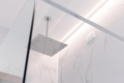 a glass shower door with a light on it at The Silk House in Como