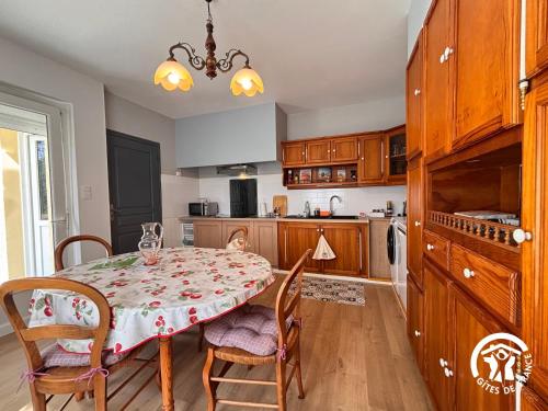 a kitchen with a table with chairs and a dining room at Gîte Nolibo in Nogaro