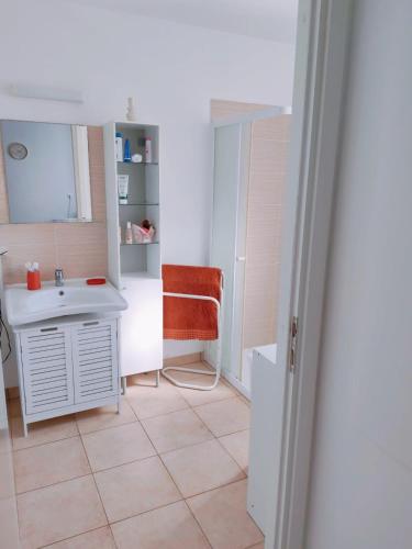 a bathroom with a sink and a chair at Mini Villa 200 m de la plage in Cervione