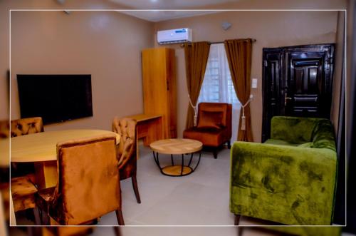 a living room with a table and chairs and a television at Atinuke Apartments in Fili