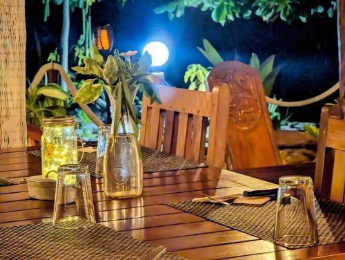 a wooden table with glasses and a vase on it at Hotel Lakana Ramena in Diego Suarez