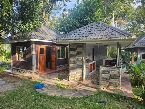 a small house with a kitchen in the yard at Nguru Farm Cottages in Wakiso