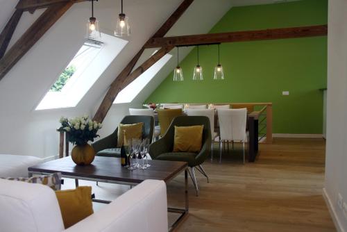 a dining room with green walls and a table with chairs at Wilgenwind in Sijsele