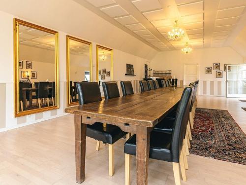 a dining room with a large wooden table and black chairs at 20 person holiday home in Svendborg in Svendborg