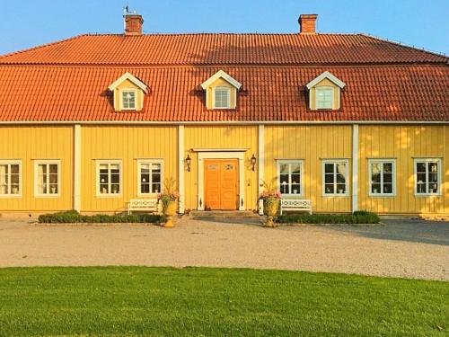 a large yellow building with a red roof at 4 person holiday home in HOVA-By Traum in Hova