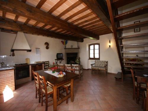 a large kitchen and dining room with a table and chairs at Nice apartment with pool and beautiful garden in Montone