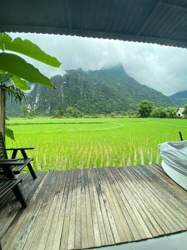 una terrazza in legno con vista su una risaia di Angsavanh Resort a Vang Vieng