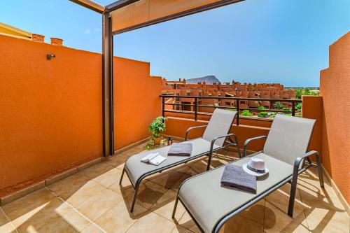 a balcony with chairs and tables on a roof at Sotavento Horizon Views Suite in La Tejita
