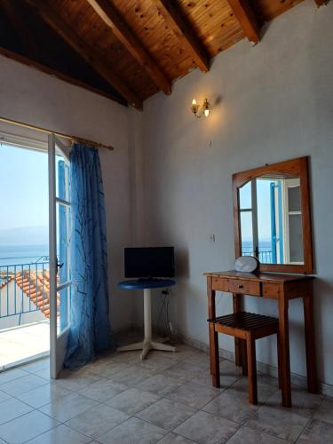 a room with a desk and a view of the ocean at Total Blue Maisonette in Koroni