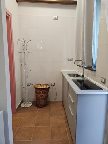 a white kitchen with a sink and a shower at La Magia Lucana in Colobraro