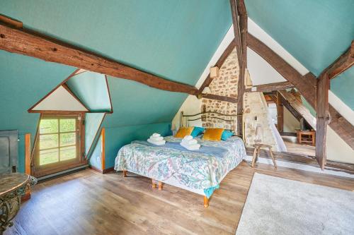 una camera da letto con letto in mansarda di Au Cèdre Bleu - Longère avec Grand Jardin a Livarot