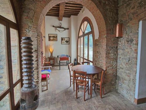a dining room with a table and a brick wall at Attractive apartment in old farmhouse on the estate with pool in Umbertide