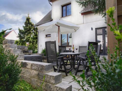 a patio with a table and chairs and an umbrella at Ground-floor apartment with terrace and large garden with lounge area and grill in Mönkebude