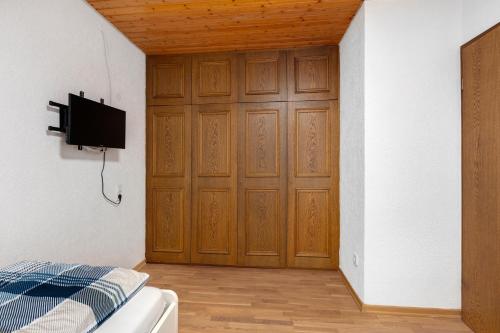 a room with a wooden door with a bed and a tv at Apartment Alte Poststation in Wehr