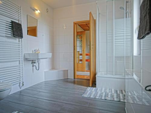 a bathroom with a shower and a sink and a toilet at Ground-floor apartment with terrace and large garden with lounge area and grill in Mönkebude