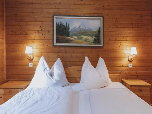 a bedroom with a white bed with a picture on the wall at holiday home, Fusch an der Glocknerstraße in Fusch an der Glocknerstraße
