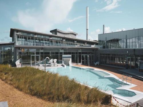 a large building with a swimming pool in front of it at Semi-detached house in St Peter-Ording in Sankt Peter-Ording