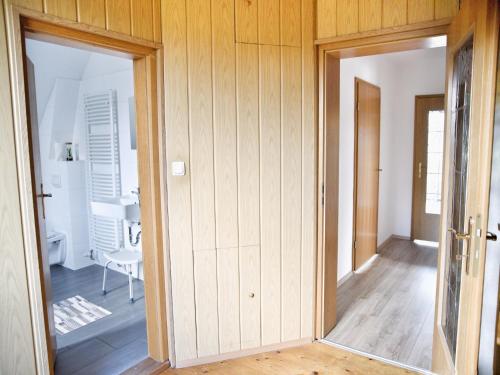 an open door to a room with wooden walls at Ground-floor apartment with terrace and large garden with lounge area and grill in Mönkebude