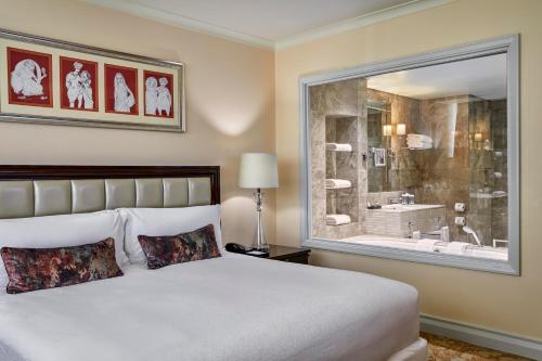a bedroom with a bed and a window with a shower at Taj Cape Town in Cape Town