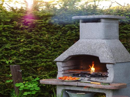 a stone oven with a plate of fruit on a table at Ground-floor apartment with terrace and large garden with lounge area and grill in Mönkebude